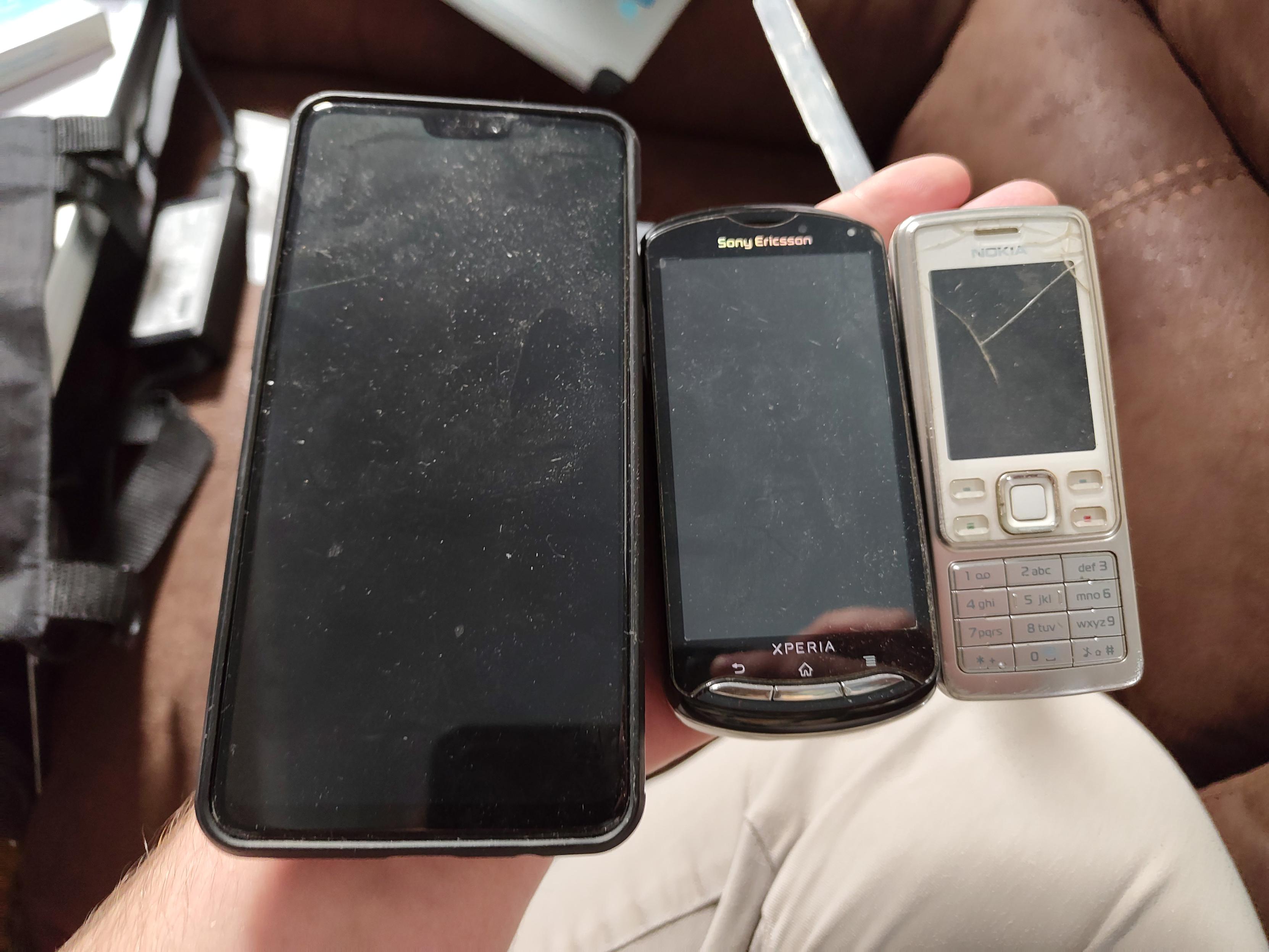 all three phones held next to each other on the flat hand, from left to right, the large oneplus 6 pro, then the much smaller mk16i, and then the smallest nolia 6300, being comparable in size to the mk16i